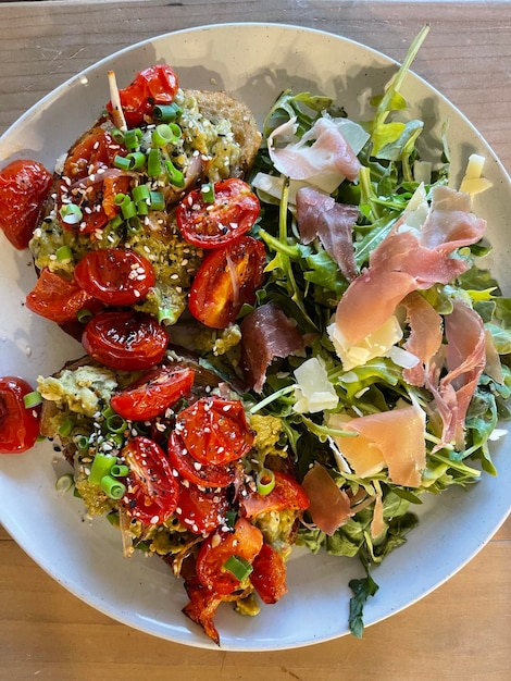 Vista de una ensalada saludable con tomates y prosciutto