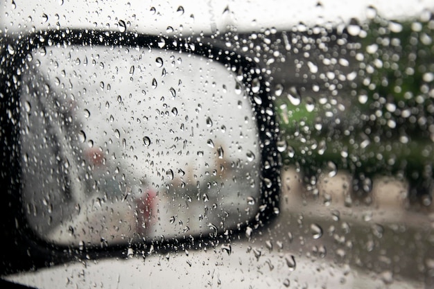 Vista de un espejo lateral del camión desde el interior del camión con condensación y lluvia en la ventana de vidrio