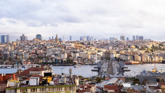 Foto vista de estambul en tiempo nublado, estrecho del bósforo que divide la ciudad en dos partes, varios edificios, puente con coches, turquía