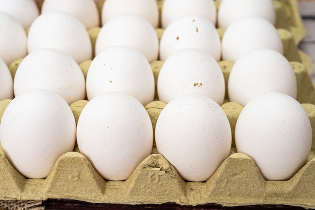 Vista explodida de um recipiente de caixa de ovo com ovos de galinha branca orgânicos.