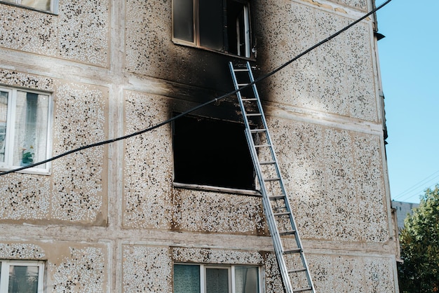 Vista exterior de los apartamentos quemados Ventana negra en el hollín del fuego y las escaleras