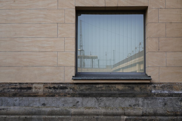 Vista exterior de la ventana de cristal en una pared de ladrillos con el reflejo de la ciudad