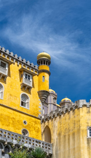 Vista externa da torre de vigia do colorido Palácio Pena amarelo sob um céu azul ensolarado Sintra