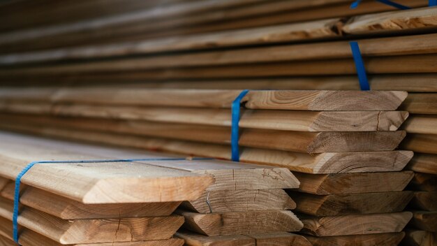 Foto vista de los extremos de los tableros de alerce de bordes apilados con borde biselado, tablones para la construcción de valla o revestimiento de casa