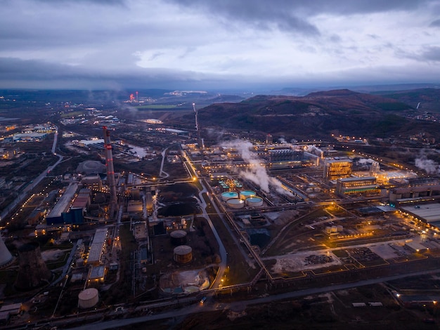 Vista de una fábrica que fuma mucho en la vista aérea del área industrial nocturna