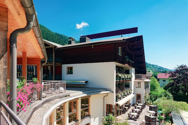 Vista con flores desde la ventana del Hotel y resort familiar en Paisaje e instalaciones al aire libre en verano. Diseño moderno. Complejo exterior para Relax en vacaciones. Cielo azul.