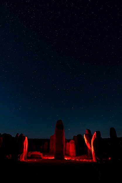 Foto vista de la formación rocosa iluminada contra el cielo por la noche