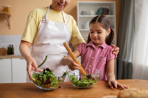 Foto vista frontal abuela y niña cocinando juntas