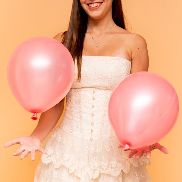Vista frontal adolescente sosteniendo globos de cumpleaños