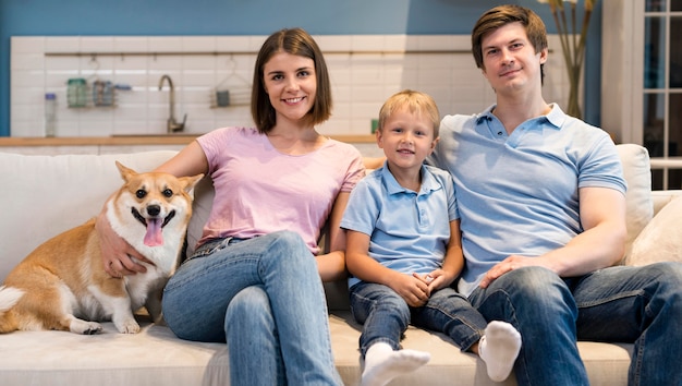 Foto vista frontal adorable familia posando junto con perro