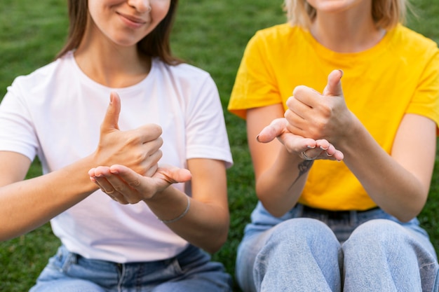 Vista frontal de amigas usando lenguaje de señas