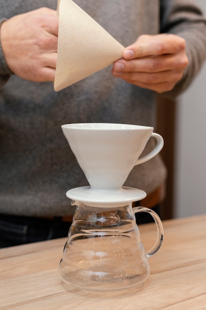 Foto vista frontal del barista masculino con filtro de café