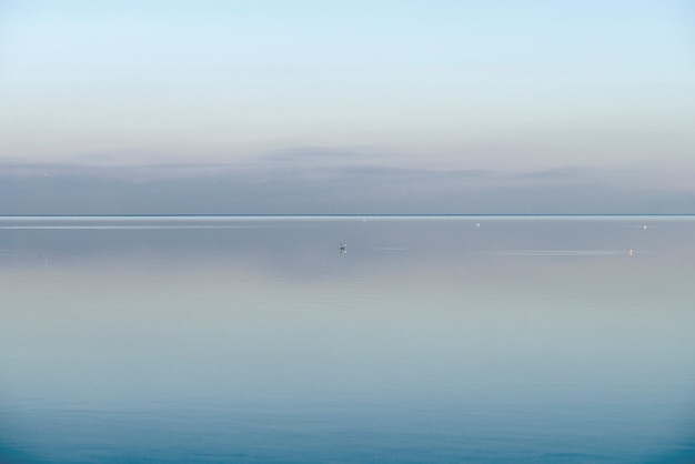 Vista frontal calma e relaxante do horizonte do oceano copie o espaço no topo Névoa sobre o mar em uma nova manhã Céu claro e azul durante uma noite tranquila de anoitecer com fundo natural