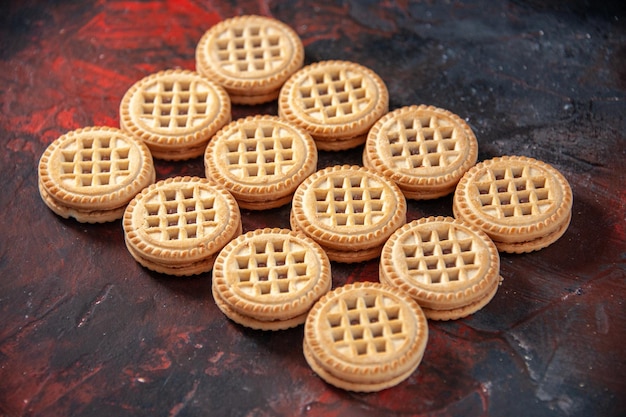 Vista frontal cercana de deliciosas galletas dispuestas en filas sobre fondo de colores mezclados con espacio libre