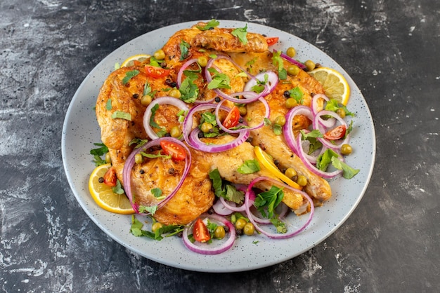 Vista frontal cercana del delicioso plato de pollo frito con varias especias y alimentos sobre fondo de color oscuro