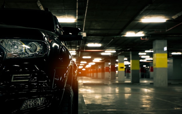 Vista frontal del coche negro estacionado en el estacionamiento subterráneo del centro comercial