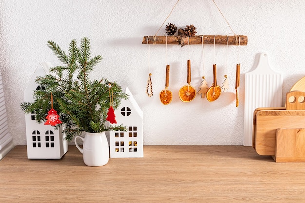 Vista frontal de una cocina moderna con artículos ecológicos, utensilios y ramas de abeto verde, ideas interiores de cocina decoradas para las vacaciones