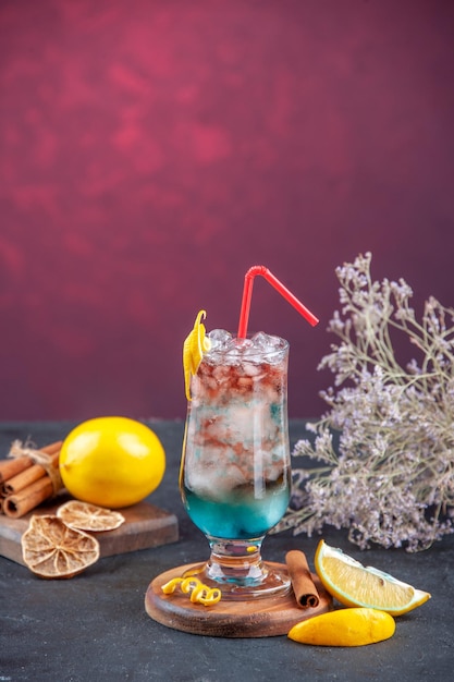 Vista frontal cóctel afrutado con paja y hielo sobre fondo oscuro color limonada bar de verano bebida de fiesta jugo fresco hielo fresco