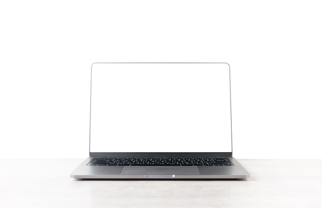 Foto vista frontal de la computadora portátil está en la mesa de trabajo aislada sobre fondo blanco, pantalla en blanco para la entrada t