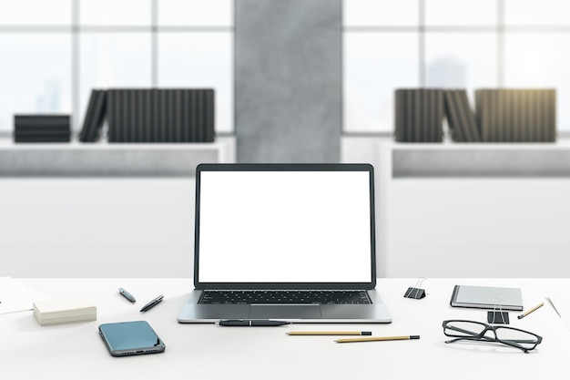 Vista frontal en una computadora portátil moderna con pantalla blanca en blanco con espacio vacío en una mesa de luz con gafas de teléfono inteligente y herramientas de oficina en estantes borrosos y maqueta de representación 3D de fondo de ventana