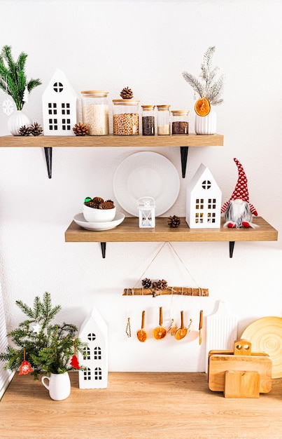 Vista frontal da bancada de madeira e prateleiras no interior da cozinha moderna com utensílios e decorações de Natal ecologicamente