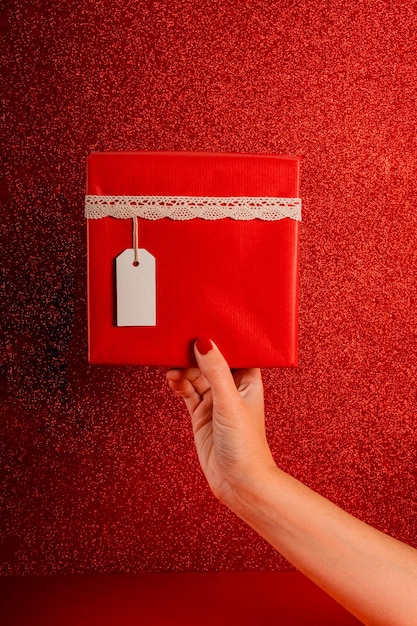 Vista frontal da caixa de presente vermelha com etiqueta branca contra fundo vermelho