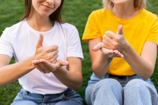 Vista frontal de amigas usando linguagem de sinais