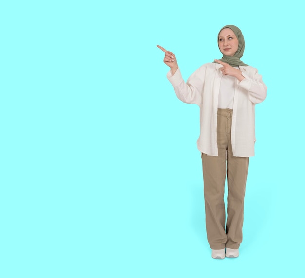 Vista frontal de corpo inteiro, jovem muçulmana caucasiana em promotora de hijab, mulher de 20 anos, ponto de lado, espaço de cópia