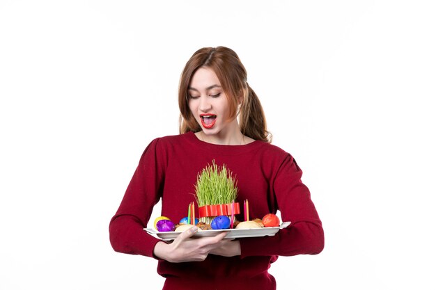 vista frontal de jovem segurando honca com doces semeni e novruz no fundo branco cores primavera etnia artista conceito étnico