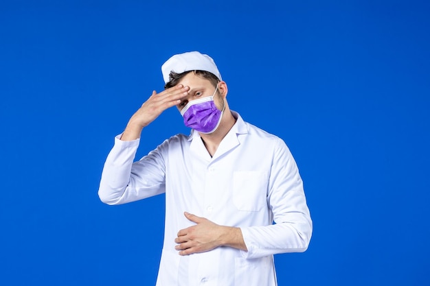 Vista frontal de médico estressado em traje médico e máscara roxa em azul