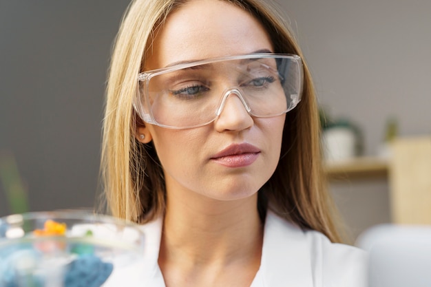 Foto vista frontal de pesquisadora com óculos de segurança no laboratório