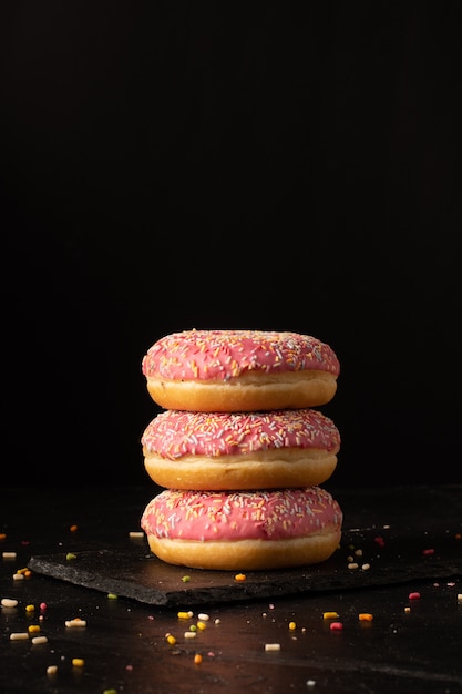 Foto vista frontal de rosquinhas de vidro com granulado na ardósia