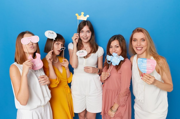 Vista frontal de um grupo de mulheres alegres para ter gênero revela fundo azul isolado do evento copiar espaço