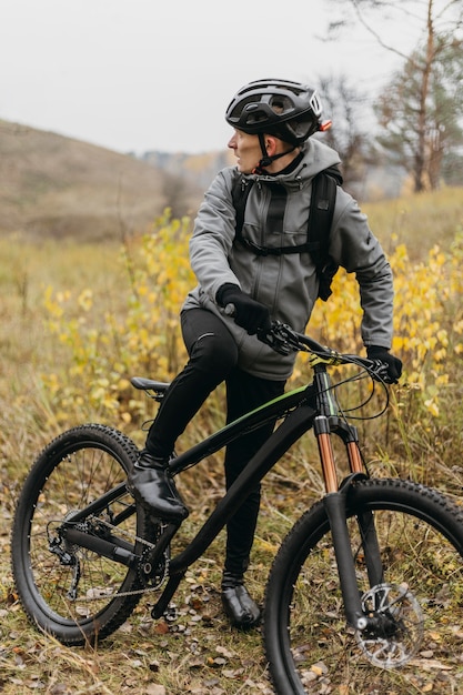 Foto vista frontal de um homem andando de bicicleta na montanha