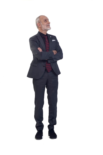 Vista frontal de um homem de pé com terno e olhando para cima no fundo branco