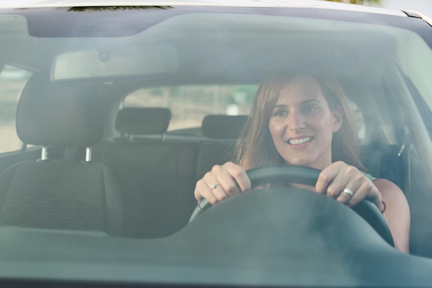 Foto vista frontal de uma jovem dirigindo seu carro