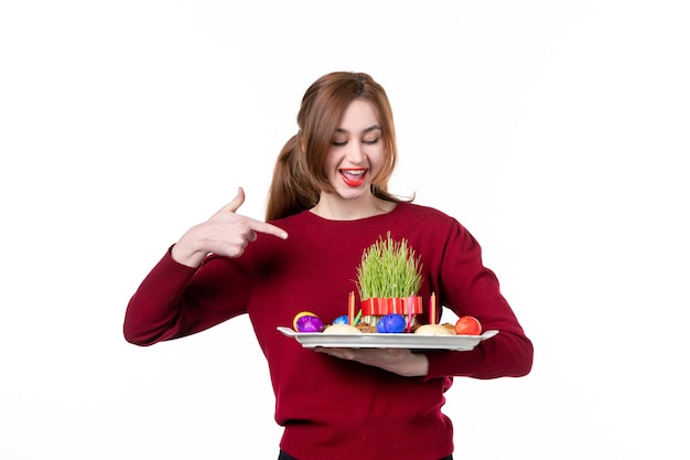 vista frontal de uma jovem mulher segurando honca com doces semeni e novruz no fundo branco cores primavera etnia artista férias conceito étnico