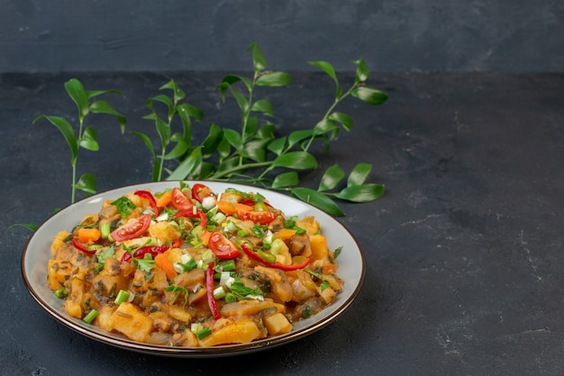 Vista frontal de uma refeição saborosa com batatas e vegetais folhas verdes em fundo preto com espaço livre