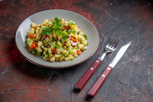 Vista frontal deliciosa ensalada de frijoles plato interior con tenedor y cuchillo superficie oscura bocadillo comida saludable cena plato color dieta pan comida