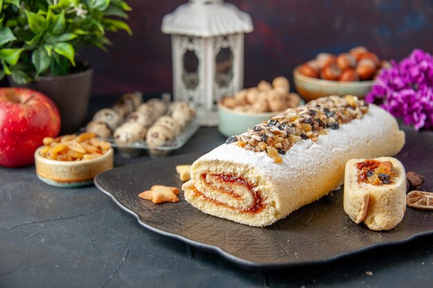 vista frontal delicioso biscoito rolo com nozes no fundo escuro torta biscoito bolo sobremesa chá açúcar doce fruta flor