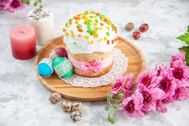 vista frontal delicioso bolo de páscoa com frutas secas e ovos coloridos na superfície branca conceito primavera colorido torta ornamentada cores de sobremesa