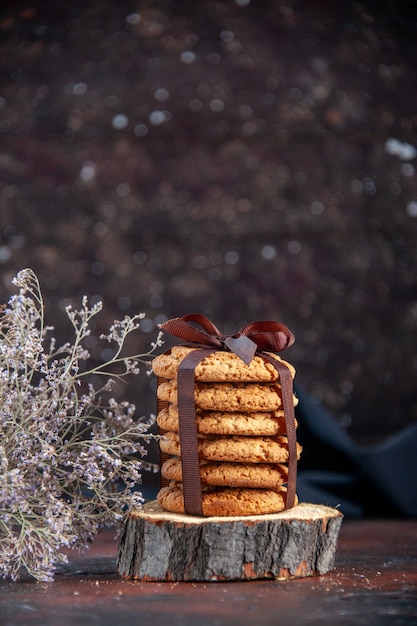 vista frontal deliciosos biscoitos doces amarrados com laço no fundo escuro biscoito torta de chá horizontal