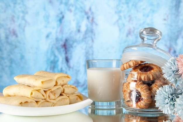 Vista frontal deliciosos panqueques con galletas y leche sobre un fondo claro, azúcar, comida, galletas, desayuno, pastel, mañana, color dulce