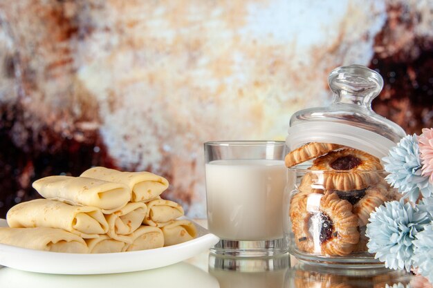 Vista frontal deliciosos panqueques con galletas y leche sobre fondo claro azúcar postre color cookie dulce comida torta mañana