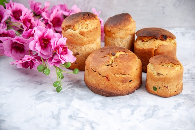 Vista frontal deliciosos pasteles de Pascua con flores sobre la superficie blanca Pascua colorido concepto de primavera pastel colores de postre ornamentados