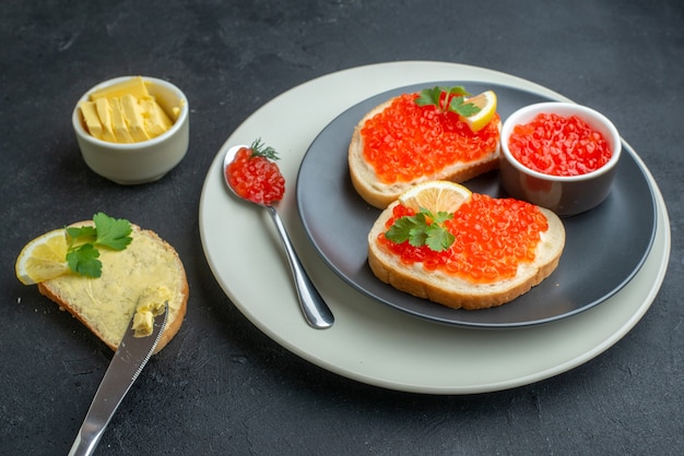 Vista frontal deliciosos sándwiches de caviar placa interior con queso sobre fondo oscuro bocadillo pescado pan plato desayuno comida cena tostadas