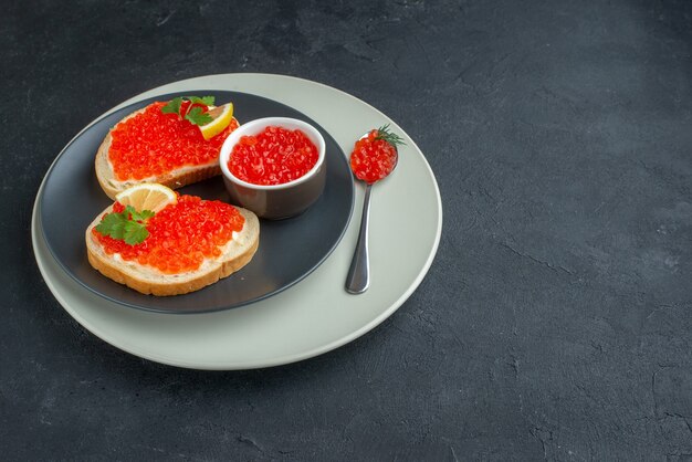 Vista frontal deliciosos sándwiches de caviar placa interior sobre fondo oscuro comida tostada pan cena plato bocadillo desayuno comida