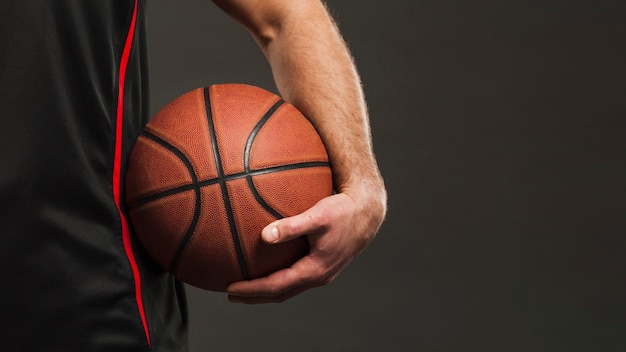 Foto vista frontal do basquete realizada pelo jogador perto do quadril