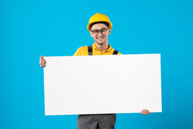 Vista frontal do construtor masculino em uniforme amarelo sobre azul