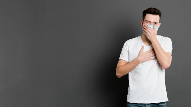 Foto vista frontal do homem posando enquanto usava uma máscara médica